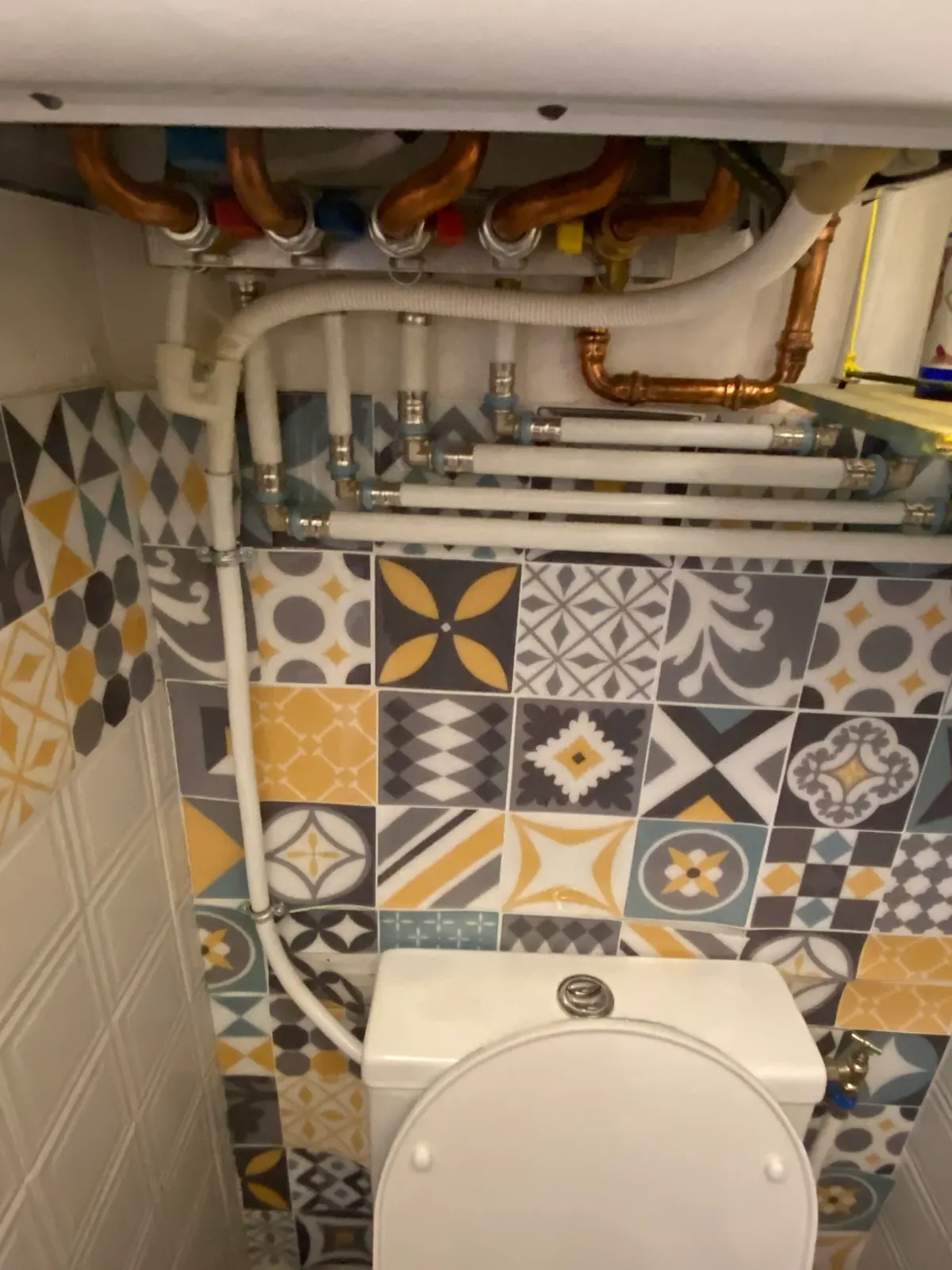 Alimentation de WC posée devant un mur en carreaux de ciment