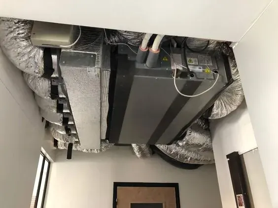 Unité de climatisation gainable dissimulée dans un faux plafond