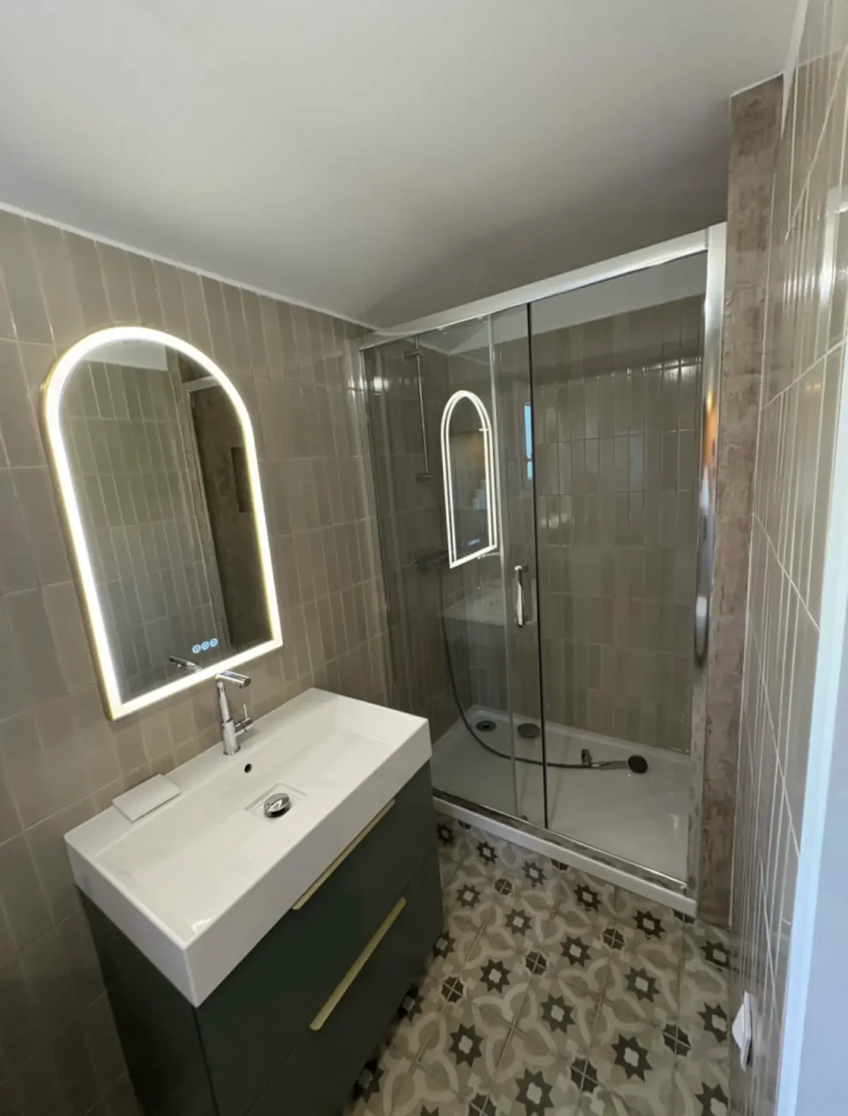 Salle de bain rénovée avec meuble vasque et miroir lumineux